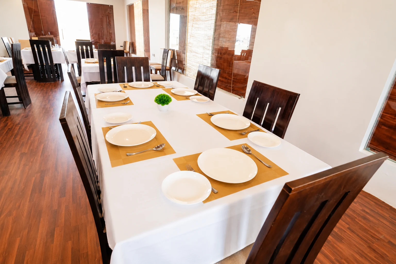 Long dining table set with gold placemats for an intimate function at J60 Suites