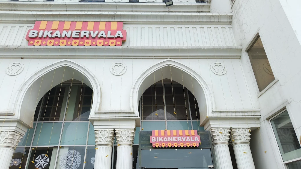 Bikanervala restaurant facade with white arched columns and the brand's pink-and-yellow signage