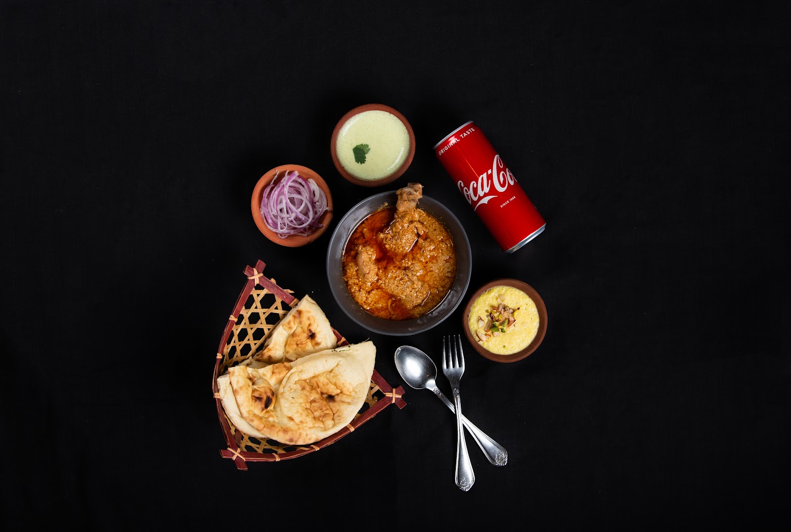 Khan Chacha platter with seekh kebab skewers, rolled flatbread wrap, green chutney and sliced onions