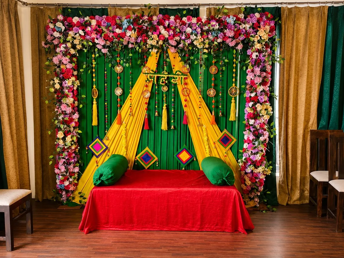 Haldi entrance with marigold arch, drape wall and carpeted walkway at J60 Suites